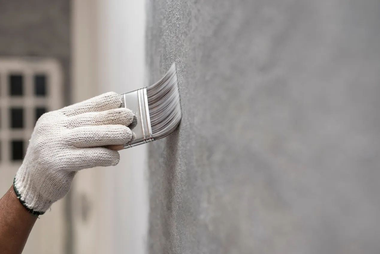 painter paints a wall grey